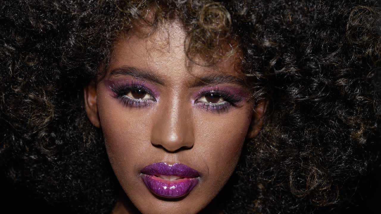 mujer elegante con maquillaje audaz y afro