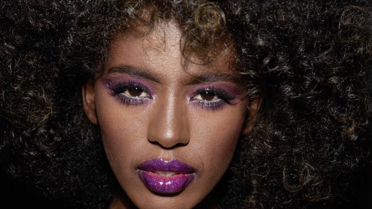 Stilfuld kvinde med markant makeup og afrohår