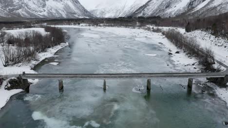 icy river with small bridge near åndalsnes, western norway in the winter