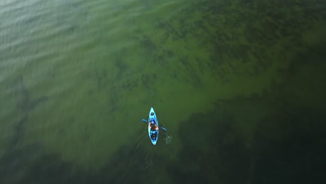 aerial view of a man kayaking clear waters in oregon, diamond lake