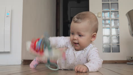 Baby-girl-playing-on-a-wooden-floor