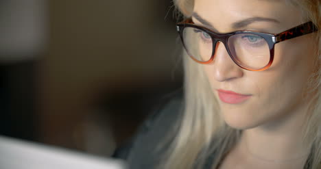 Businesswoman-Wearing-Eyeglasses-While-Using-Laptop-In-Office