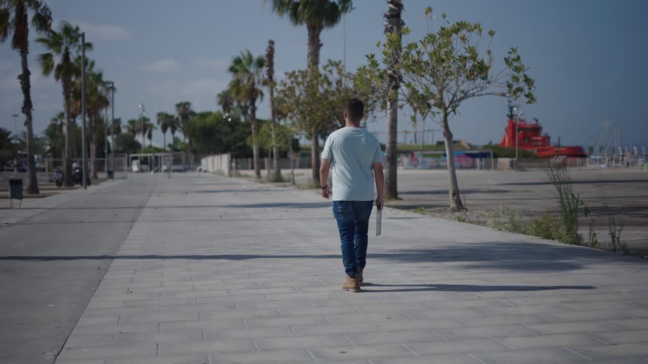 Man Walking on a City Promenade