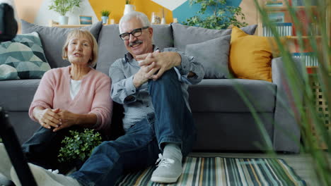 senior couple recording a video blog at home
