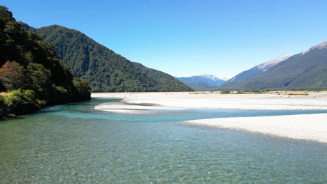 Aerial-view-of-the-Haast-River-Valley-New-Zealand-on-a-sunny-day,-Truck-shot