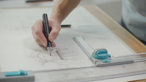 un ingeniero dibuja edificios en la mesa usando un lápiz y una regla. un arquitecto crea un diseño de edificio en papel usando un marcador y una regla