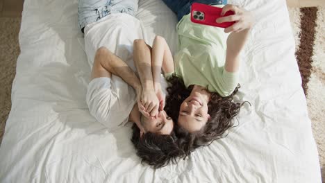 Pareja-Joven,-Acostado,-En-La-Cama,-Y,-Tomar,-Un,-Selfie,-Juntos