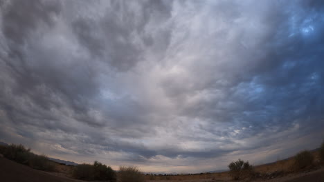 Dark-storm-clouds-produce-a-rare-cloudburst-over-the-arid-Mojave-Desert-basin---static-wide-angle-time-lapse