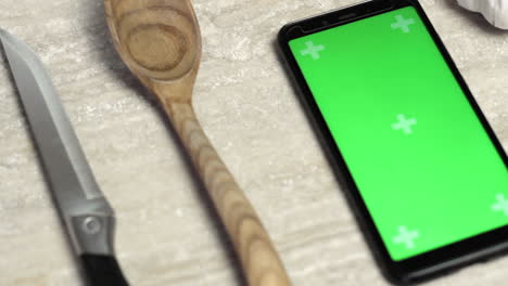smartphone with tracking points green screen on kitchen table, closeup