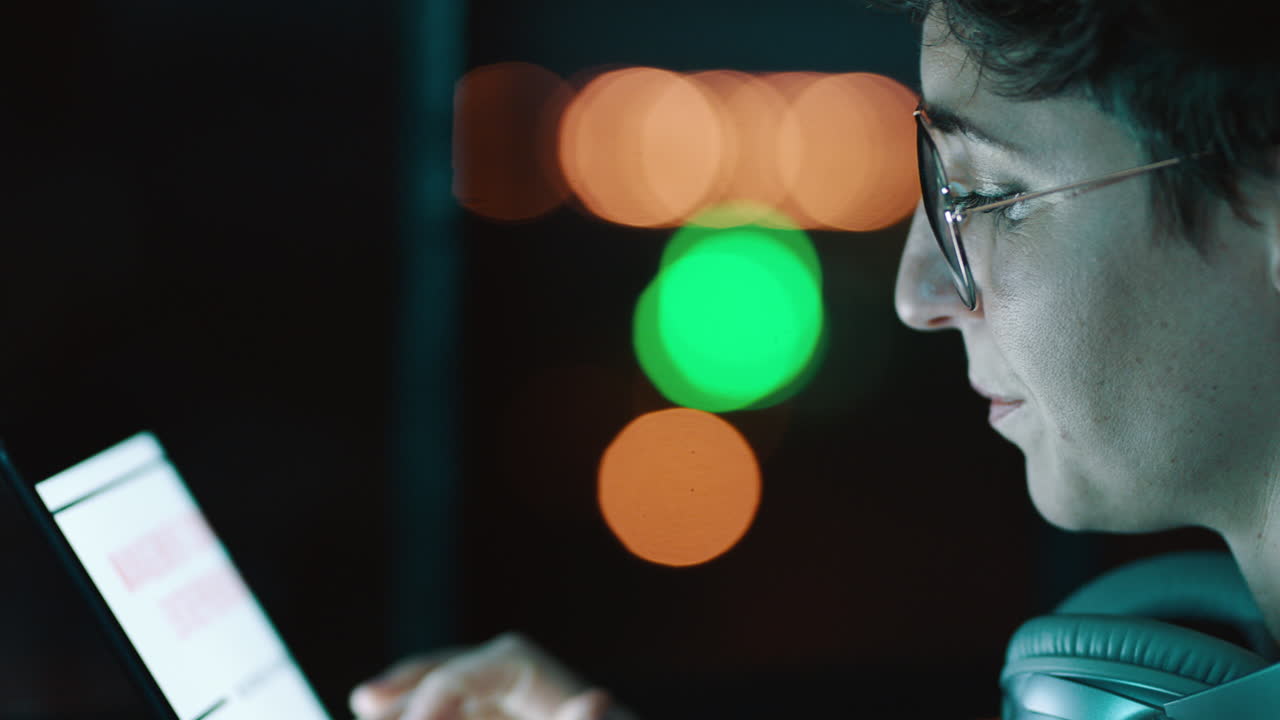 Focused Young Person Using Digital Tablet at Night