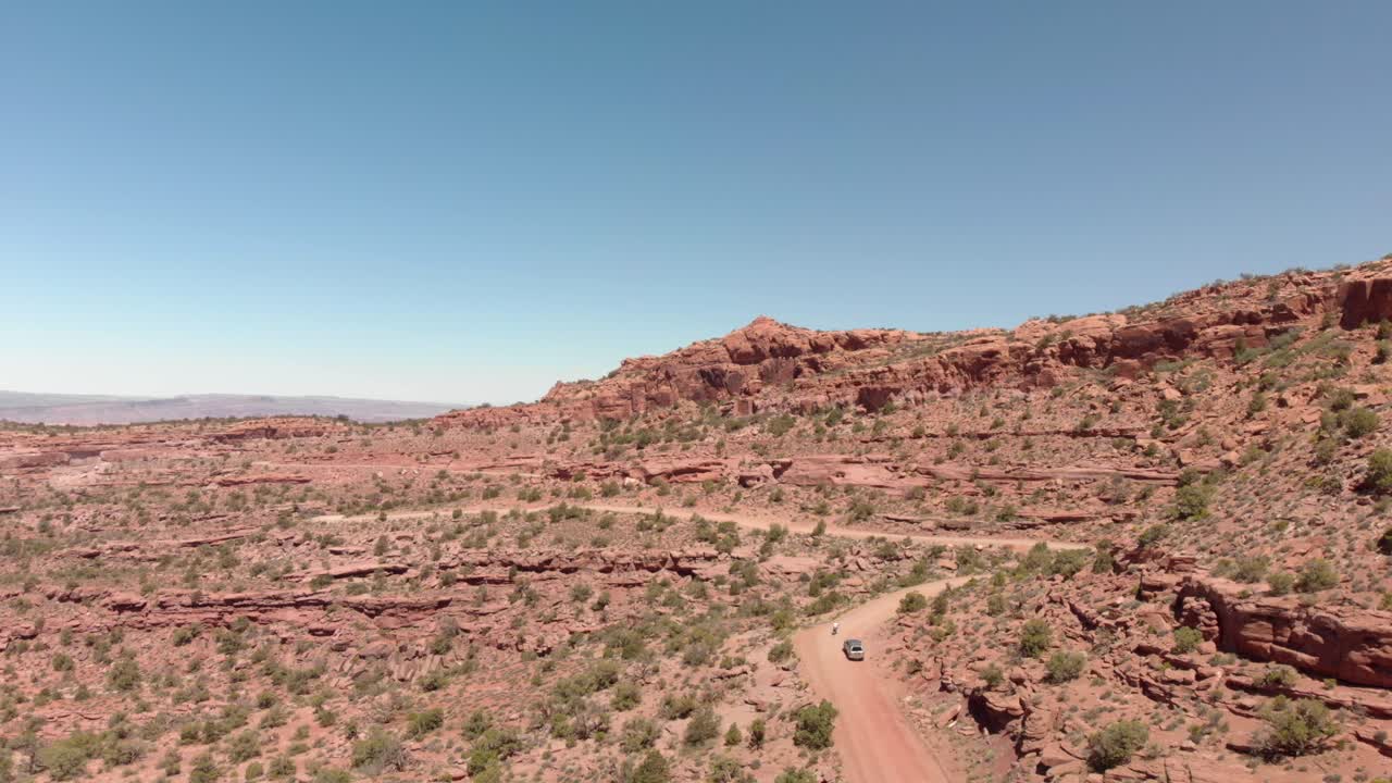 Moto sorpassa SUV: Vista aerea, guida nei canyon vicino a Moab