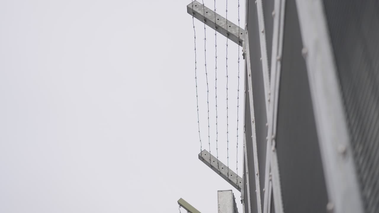 alambre de púas alrededor de la prisión con cielo gris en el fondo