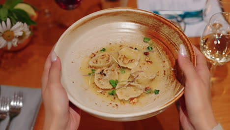 close up slow motion of a course of tortelloni pasta being put on the table. traditional italian cuisine.