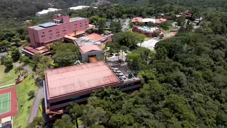 aerial drone view of a luxury resort surrounded by greenery and scenic hills. rotation view