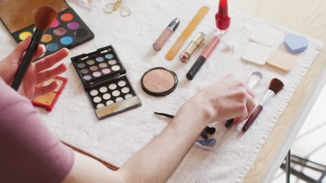 mujer transgénero caucásica no binaria haciendo maquillaje