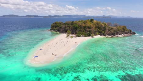 aerial view of tacling island in linapacan, philippines, featuring white sandy shores, turquoise waters, coral reefs, and lush vegetation surrounded by the sulu sea