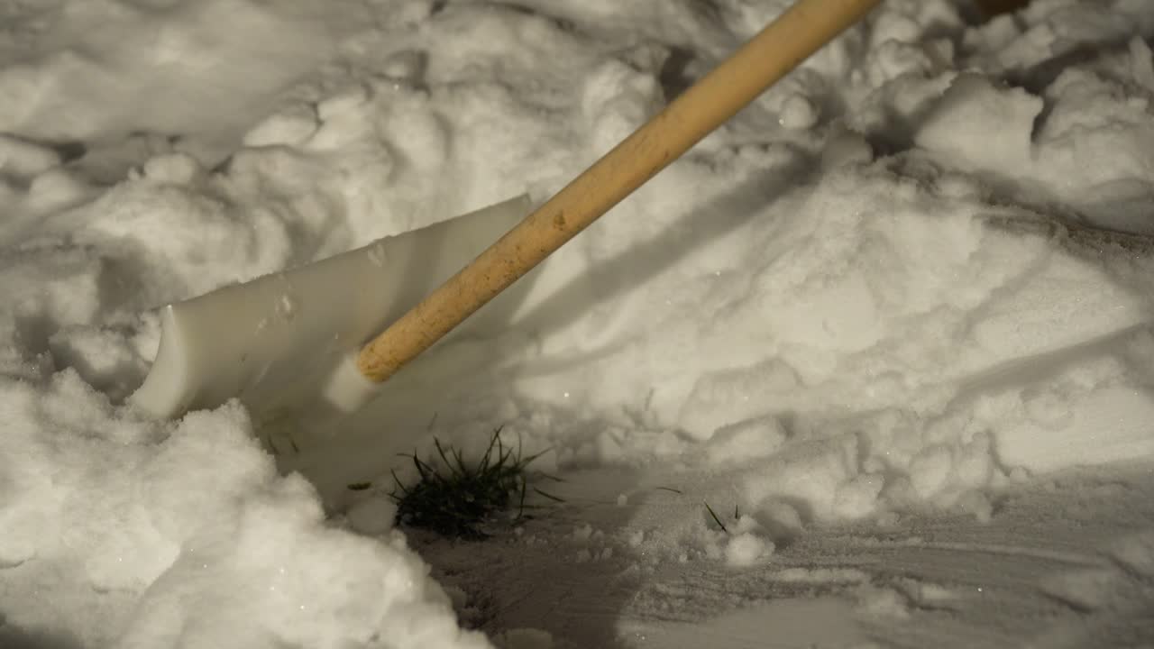 Shovel clearing snow from a path, showing winter maintenance and removal of frozen precipitation