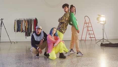 portrait of happy diverse male and female dancers posing in dance studio, slow motion