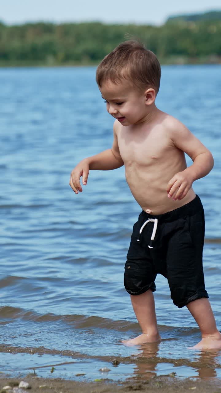 Summer child having fun on a river. Water summertime lifestyle. Vertical video