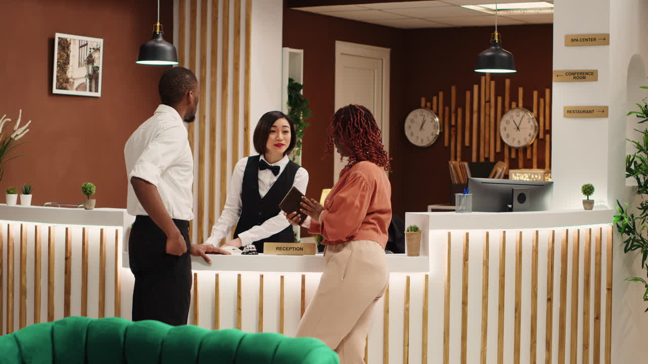 Cheerful receptionist booking in guests