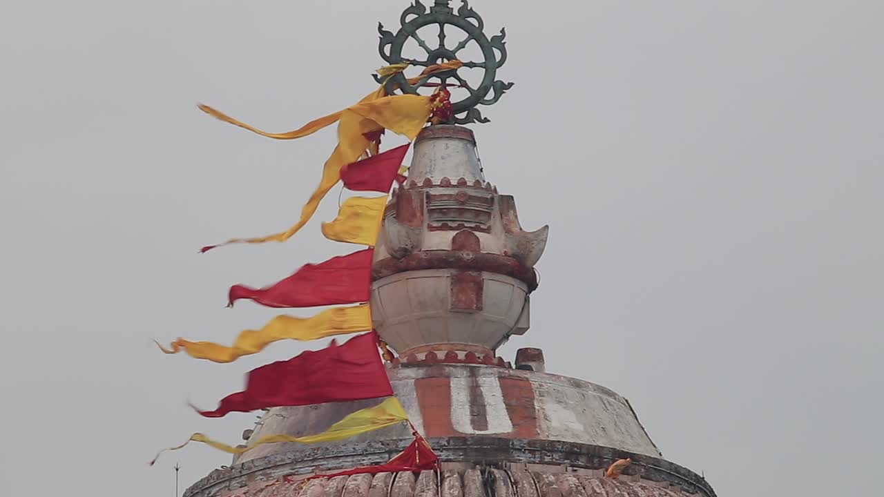 banderas rojas y amarillas vuelan sobre un templo religioso en india