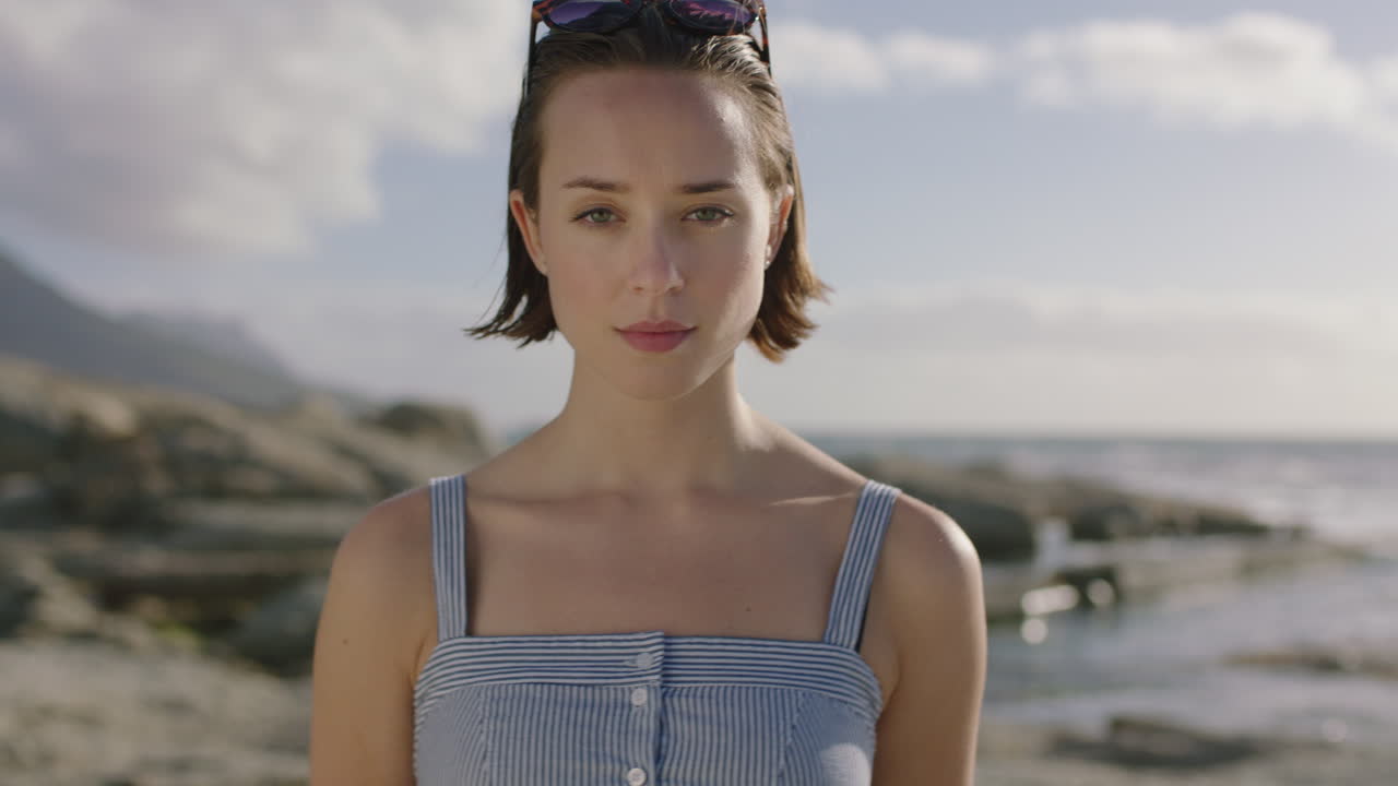 Nærbillede af en ung, selvsikker og stærk kvinde på stranden.