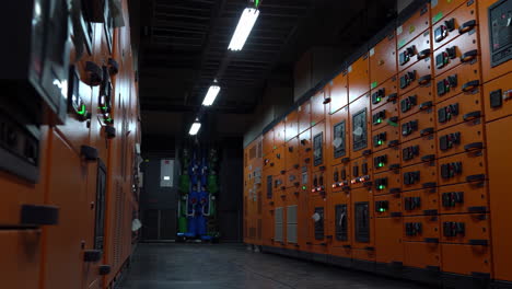 industrial data center with rows of yellow server cabinets, power distribution device, industrial power distribution panel for control, safety and protection system of a substation in a power plant