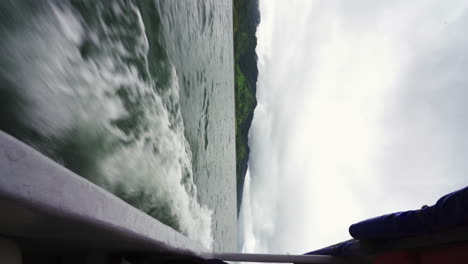 barco vertical cruzando rápidamente el lago natural de la laguna arenal en costa rica, centroamérica.