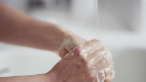 an unrecognizable woman washing her hands