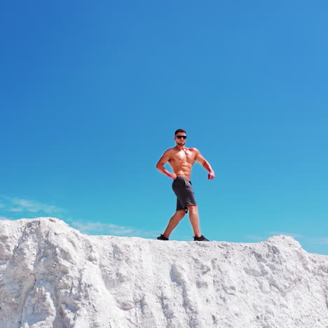 Professional bodybuilder posing. Concept of sport outdoors. Aerial view.