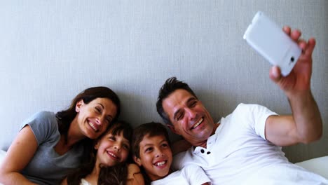 Glückliche-Familie,-Die-Ein-Selfie-Auf-Dem-Bett-Im-Schlafzimmer-Macht