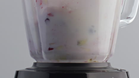 mezclador mezclando frutas de leche en un primer plano súper lento. batido de vitaminas.
