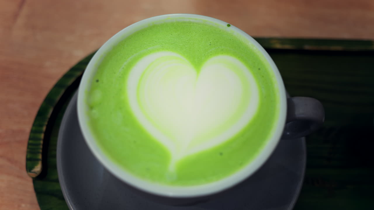 Close up of a matcha latte on a black tray at a cafe