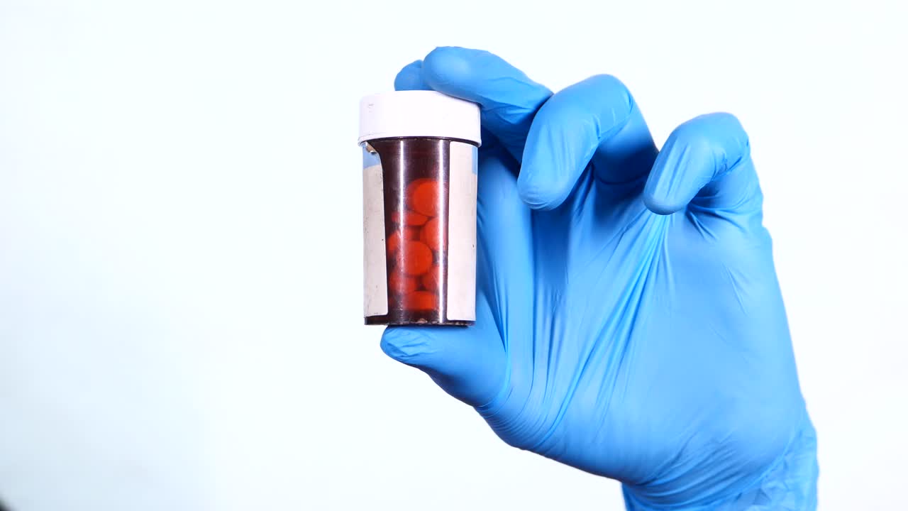 médico sosteniendo un recipiente de pastillas