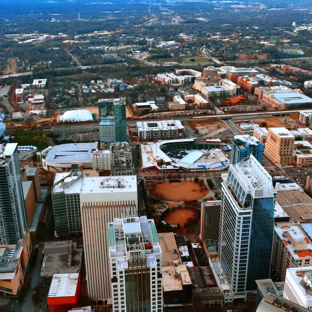 Flying above the tops of the highest buildings of Charlotte, North Carolina, USA. Vast panorama of the city at daytime.