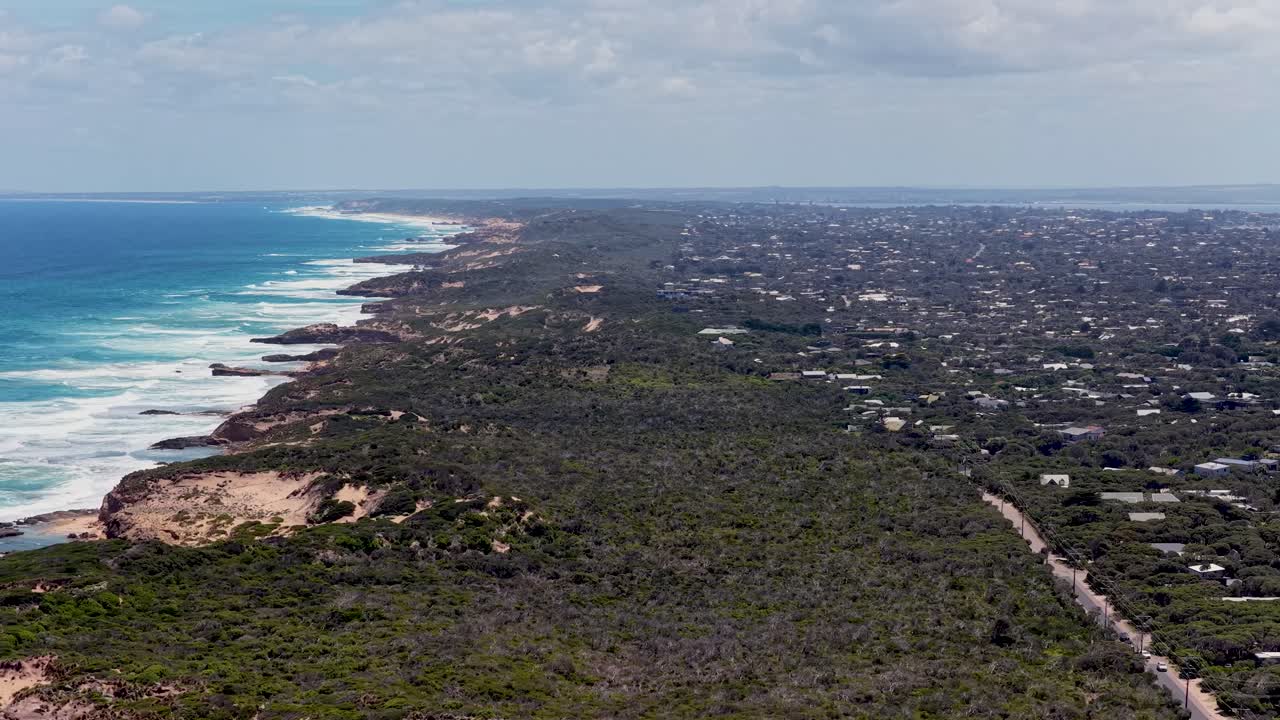 Uma foto de drone em um ângulo alto captura ondas quebrando contra o litoral acidentado perto de Portsea e Rye