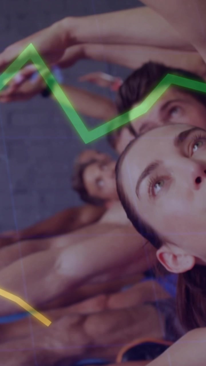 Video vertical: Clase de fitness estirándose en colchonetas azules, la cámara se desplaza mostrando métricas que rastrean la forma física.