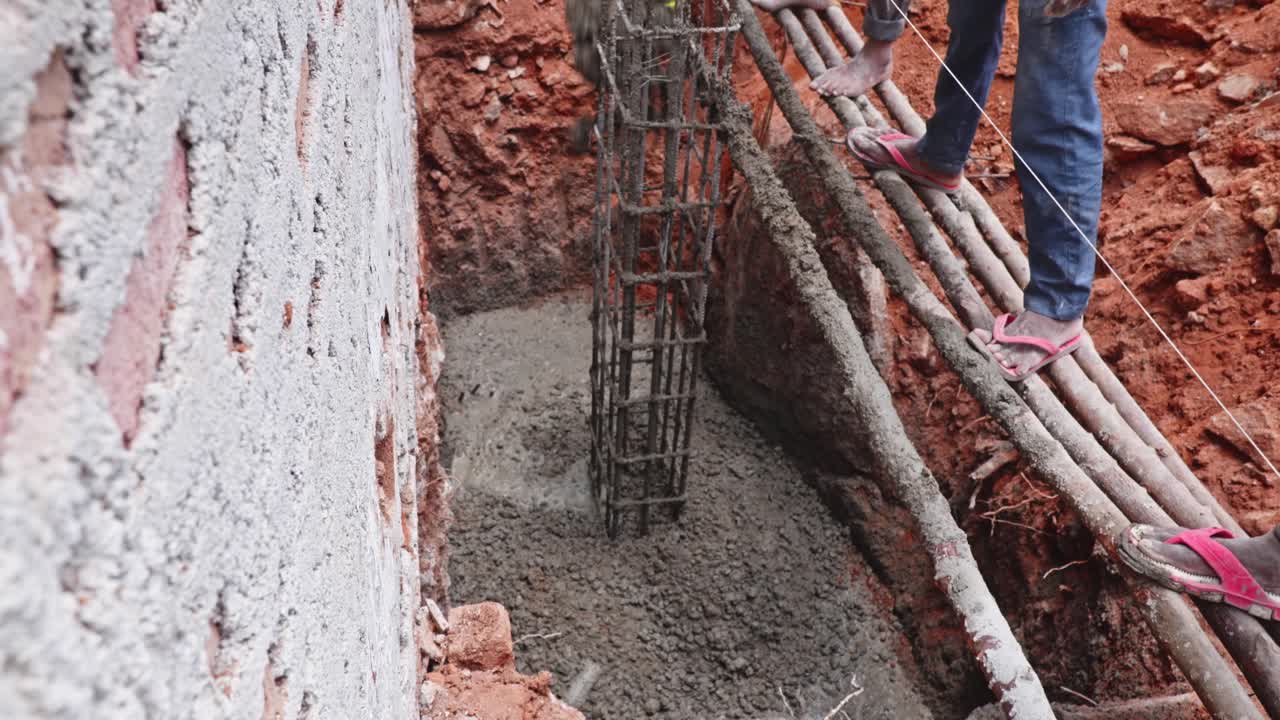 Concrete Pouring Around Rebar Cage for Column Footing at Construction Site. day time, stable shot, top down shot, 4k