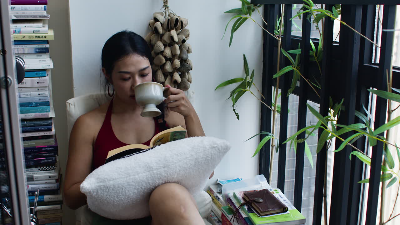 mujer leyendo un libro junto a la ventana