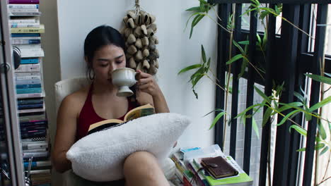 woman reading a book by the window
