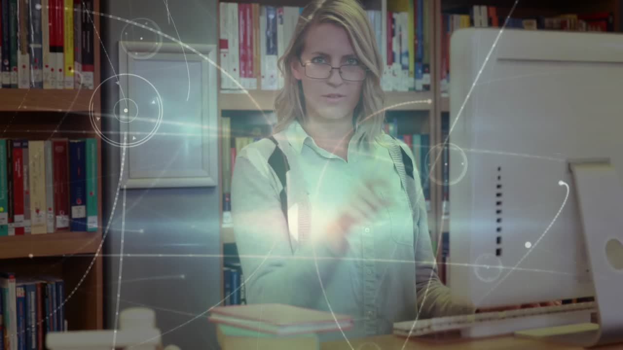 Donna adulta che digita alla scrivania, avviando la proiezione di un'interfaccia AR per la selezione di nodi, quindi riprendendo a digitare.