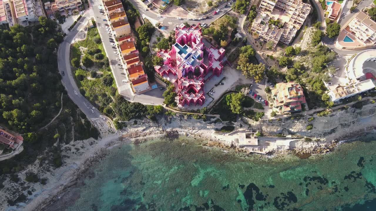 Aerial top-down overview of Muralla Roja in Calpe, Spain, featuring the iconic red walls and geometric architecture beside the ocean