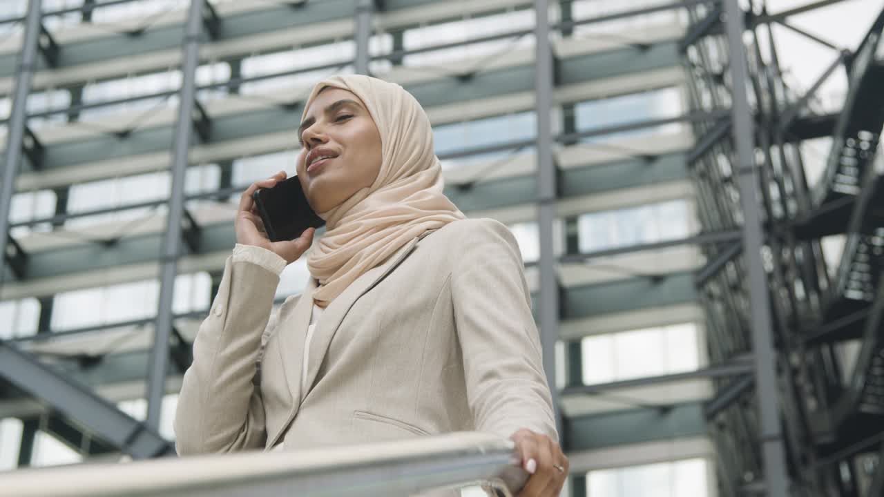 Muslim Businesswoman On Mobile Phone Standing Outside Office In City