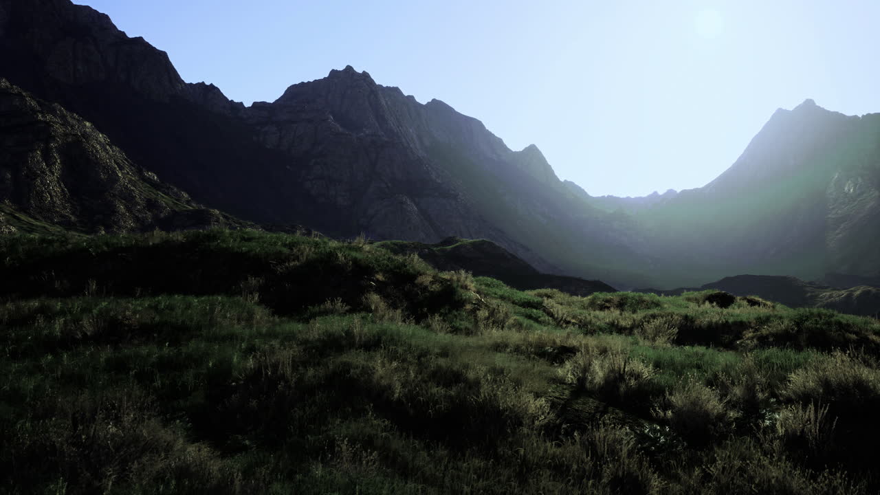 Serene mountain landscape at dawn with lush grass and rugged peaks