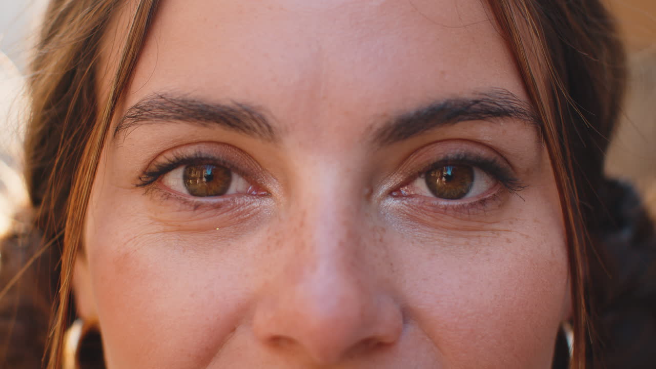 Extreme closeup macro portrait of young face pretty womans eyes looking at camera smiling