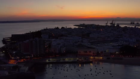 sunset over coastal city with port