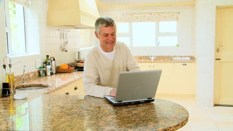 Hombre-Usando-Una-Computadora-Portátil-En-La-Cocina