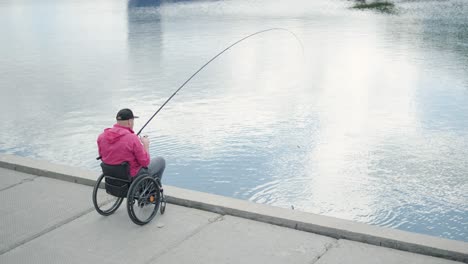 persona con discapacidad física que utiliza silla de ruedas para pescar en el muelle de pesca