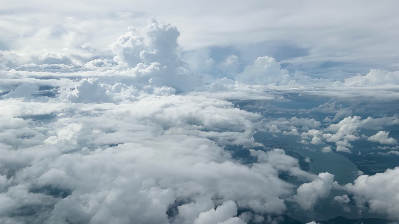 Slow aerial flight above dense cumulus cloudscape over ocean, with soft daylight and minimal movement