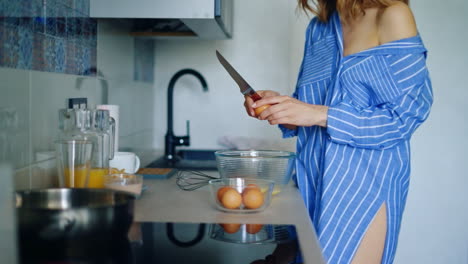 mujer en pijama preparando el desayuno tradicional con huevos